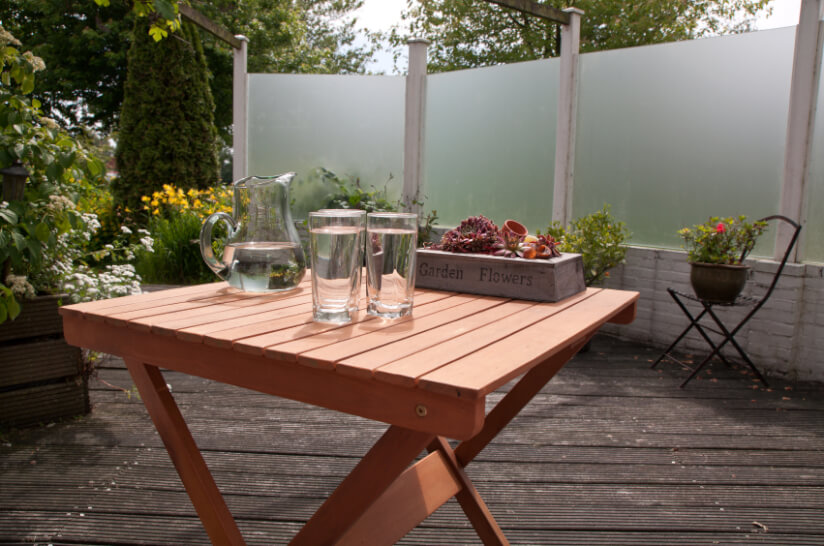 Terrassentisch im Garten mit drei Wassergläsern