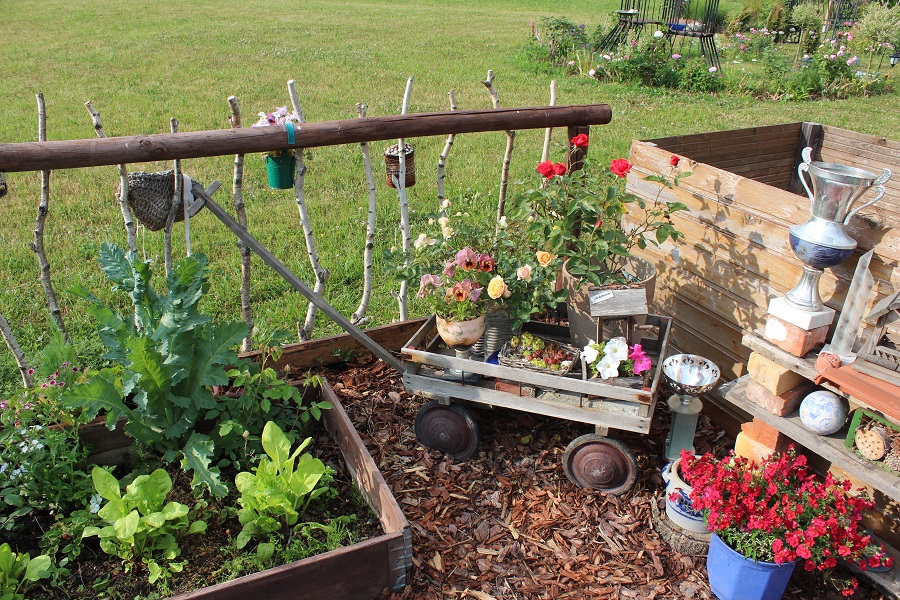 Ein kleiner Wagen voller Blumen und ein rustikaler Zaun aus Ästen: Daniela hat das richtige Gespür für die passende Deko.