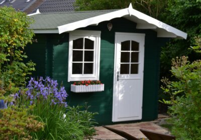 Checkliste Gartenhaus: Das müssen Sie zu Planung und Aufbau wissen grün gestrichenes kleines Gartenhaus