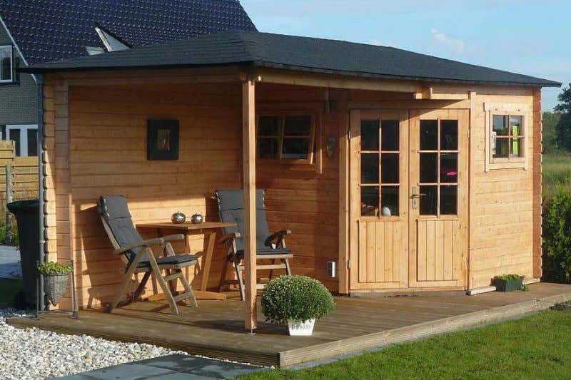 Das 5-Eck-Gartenhaus Mosel-28 aus naturbelassenem Holz mit Anbau bietet einen tollen Sonnenplatz.
