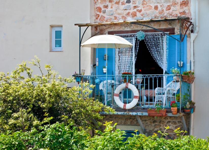 Blauer Balkon mit Sonnenschirm