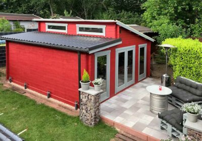 Mut zur Farbe: Rotes Gartenhaus mit Innensauna