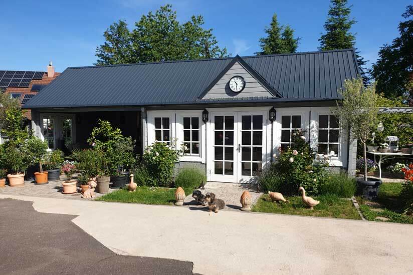 Gartenhaus in grau gestrichen mit überdachter Terrasse