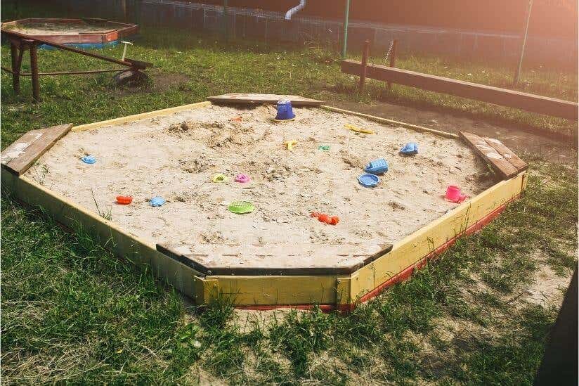 Sandkasten aus Holz mit Spielzeug